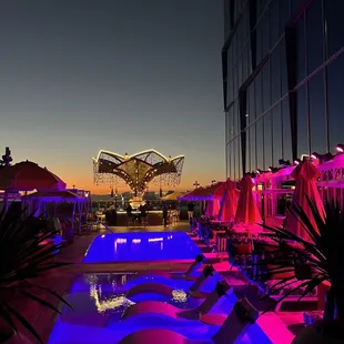 a pool with lounge chairs and umbrellas