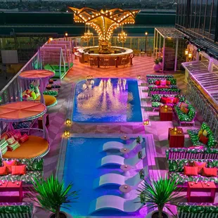 a view of a pool and a carousel at night