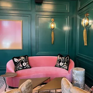 a pink couch and chairs