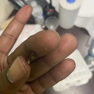a hand holding a tiny piece of metal