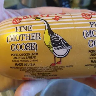 a close up of a person's hand holding a wrapped sausage