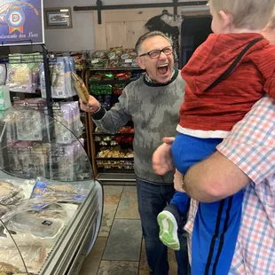a man holding a child in a grocery store