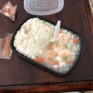 a tray of rice and vegetables on a table