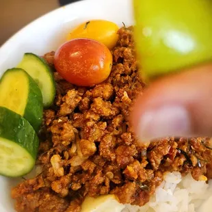 Squeezing lime on the Kapki Ti made with pork, coconut milk, dried chili, garlic, kefir lime leaves &amp; shrimp paste.