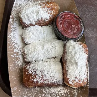 Beignets with powdered sugar and strawberry sauce - really flaky and good