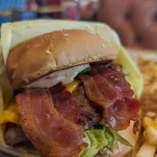 a bacon and cheese sandwich with fries