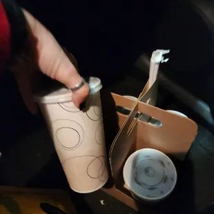 a person opening a cup of coffee