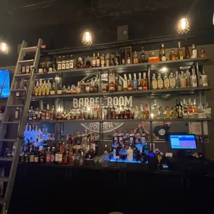 a ladder leaning against a bar filled with liquor bottles