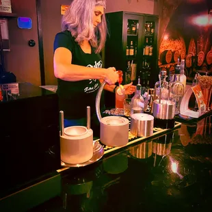 a woman pouring a drink at a bar
