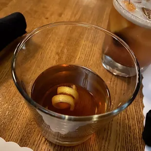a glass of tea with a lemon peel in it