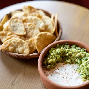 a bowl of guacamole and a bowl of chips