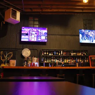 a bar with two televisions on the wall