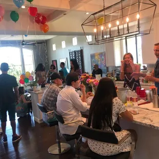 a group of people gathered around a kitchen island