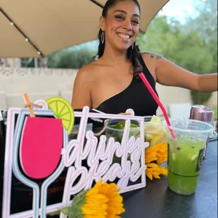 a woman sitting at a table with drinks