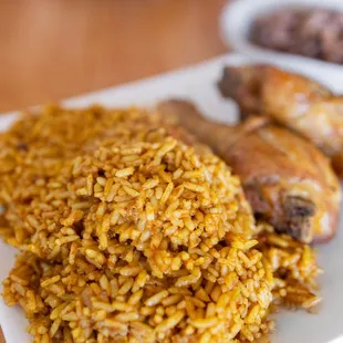 Jollof Rice w/ added Fried Chicken ($12 + $5/chicken) also comes w/ plain beans pictured in background