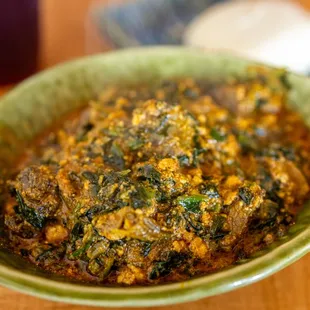 Egusi - African Melon Seed &amp; Vegetable Soup w/ Goat Meat ($18.99 + $3/Goat) also comes w/ FuFu pictured in background