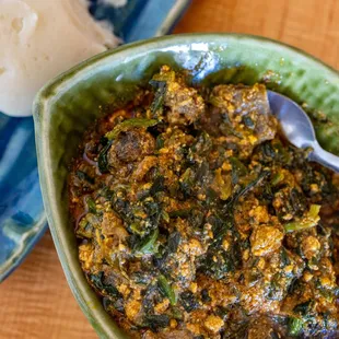 Egusi - African Melon Seed &amp; Vegetable Soup w/ Goat Meat ($18.99 + $3/Goat) also comes w/ FuFu pictured in background