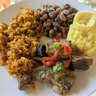 Goat asun special with black eyed peas, jollof rice, and fufu.