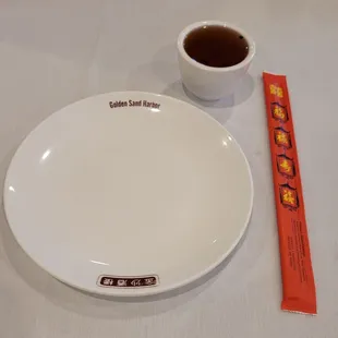 a white plate and a cup of coffee