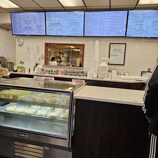 a man standing in front of a bakery counter