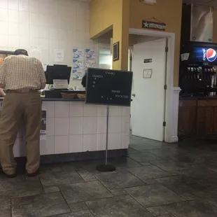 two men standing at the counter of a fast food restaurant