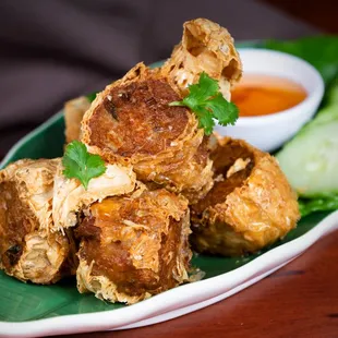 a plate of fried food with a side of dipping sauce