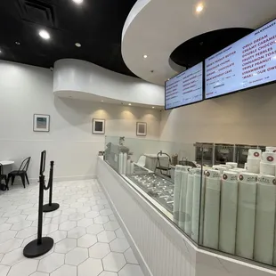 a restaurant with a large menu on the wall