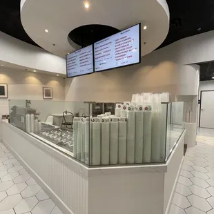 a restaurant counter with a menu on the wall