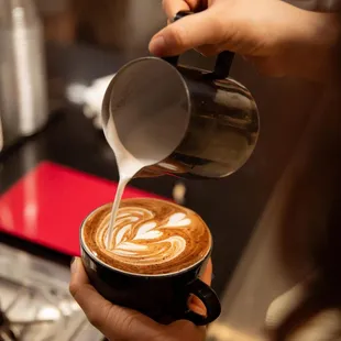 a woman pouring coffee into a cup