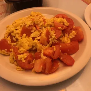 a plate of scrambled eggs and tomatoes