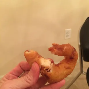 a hand holding a half eaten doughnut