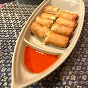 a plate of spring rolls and dipping sauce