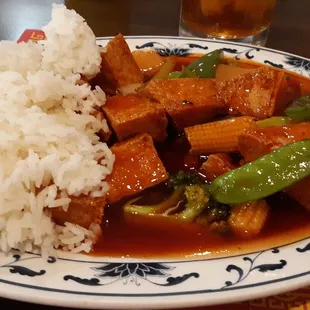 a plate of food with rice and tofu