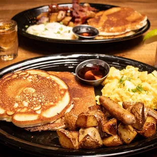 a breakfast of pancakes, eggs, hash browns, and hash browns