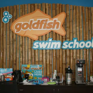 Behind the front counter and logo.