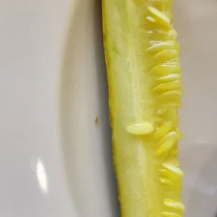 a sliced pickle on a plate