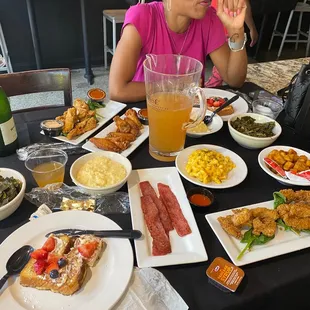 a woman sitting at a table full of food
