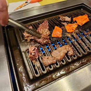 a person grilling steaks on a grill