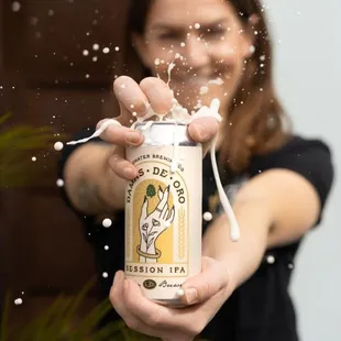 a woman holding a can of beer