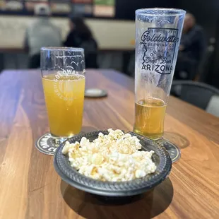 a plate of popcorn and a glass of beer