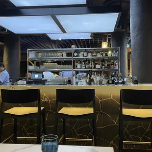 a view of a restaurant with a bar and chairs