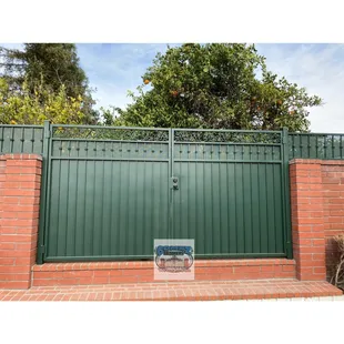 Double swing gate with 2 ft fence on top of block wall.