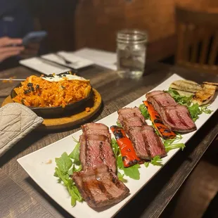 a plate of steak and rice