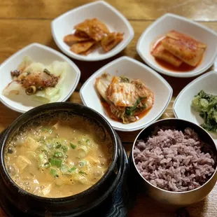a variety of bowls of food on a wooden table