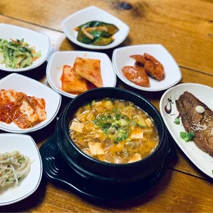a variety of dishes of food on a wooden table