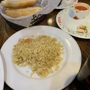 Side of rice with the plate and free breadsticks.