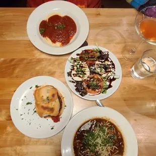 Top to bottom small happy hour plates:cheese ravioli. Caprese salad, eggplant slider, minestrone.