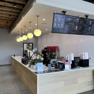 a coffee shop with a menu on the wall