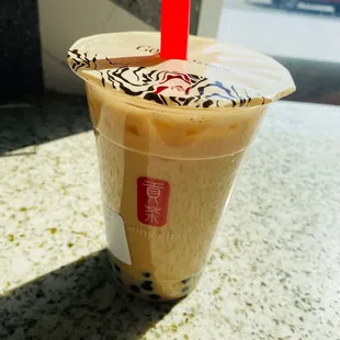 a cold drink in a plastic cup with a red straw