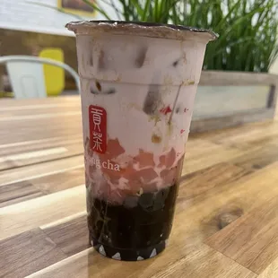 Strawberry taro milk tea with boba and star shaped peach coconut jellies.